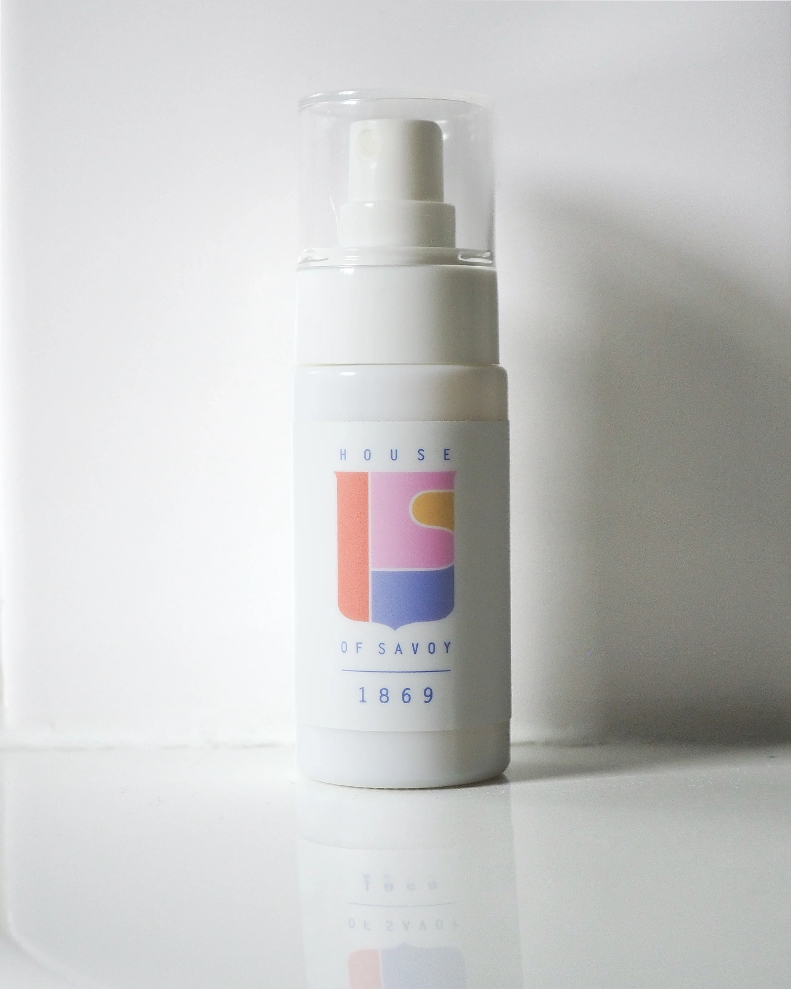 A clear spray bottle labeled '1869 it savoy' with a white label and multicolored branding, representing a cologne fragrance.