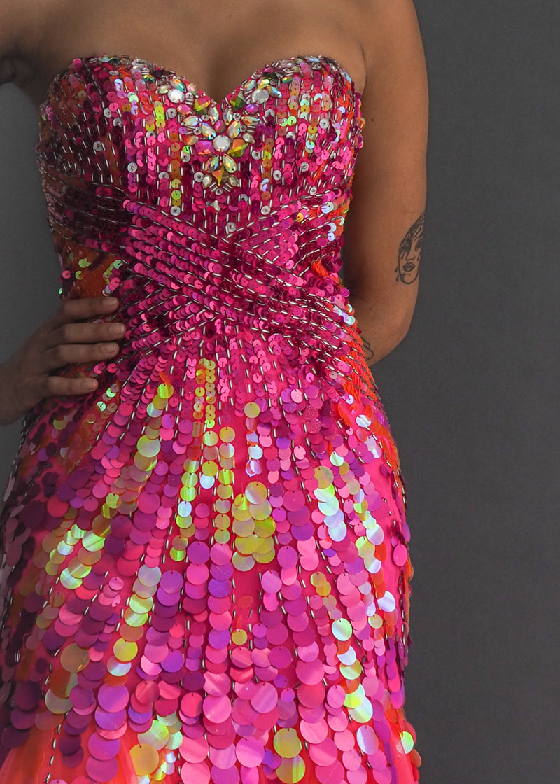 Neon Alyce Paris mermaid style gown with layers of luminescent orange and fuchsia tulle sprouting from a drop-bodice heavy in holographic sequins.