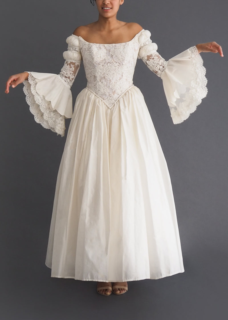 Guzzo Toronto medieval look bridal gown with scalloped bell sleeves, corseted bodice with laced back closure and cote slashed shoulder detail. 