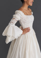 Guzzo Toronto medieval look bridal gown with scalloped bell sleeves, corseted bodice with laced back closure and cote slashed shoulder detail. 