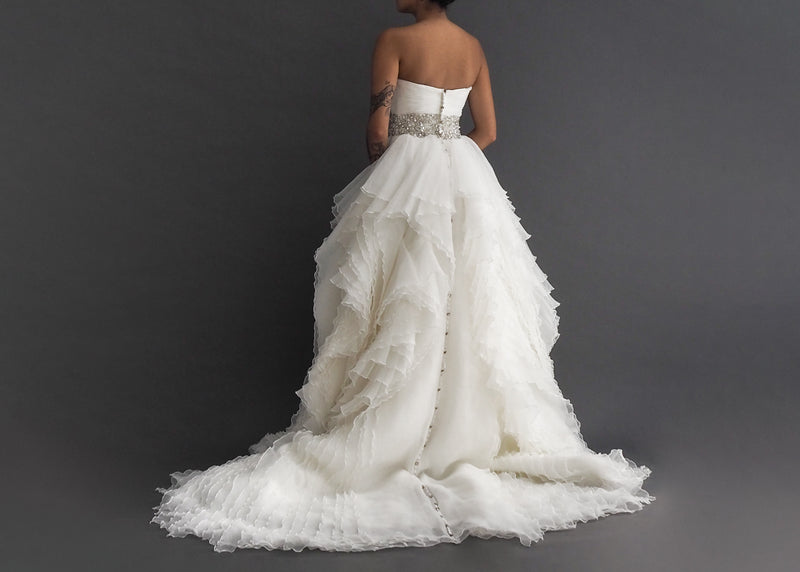 Justin Alexander wedding gown with strapless sweetheart pleated bodice, crystal encrusted waist detail, separating layers of ruffled skirt including generous button lined train.