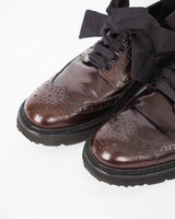 Prada oxblood brogue style shoe with traditional perforated leather uppers, taffeta ribbon lacing and heavy tread rubber sole.
