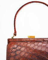 Vintage embossed, rust coloured, alligator purse with single top handle and neat rectangular shape